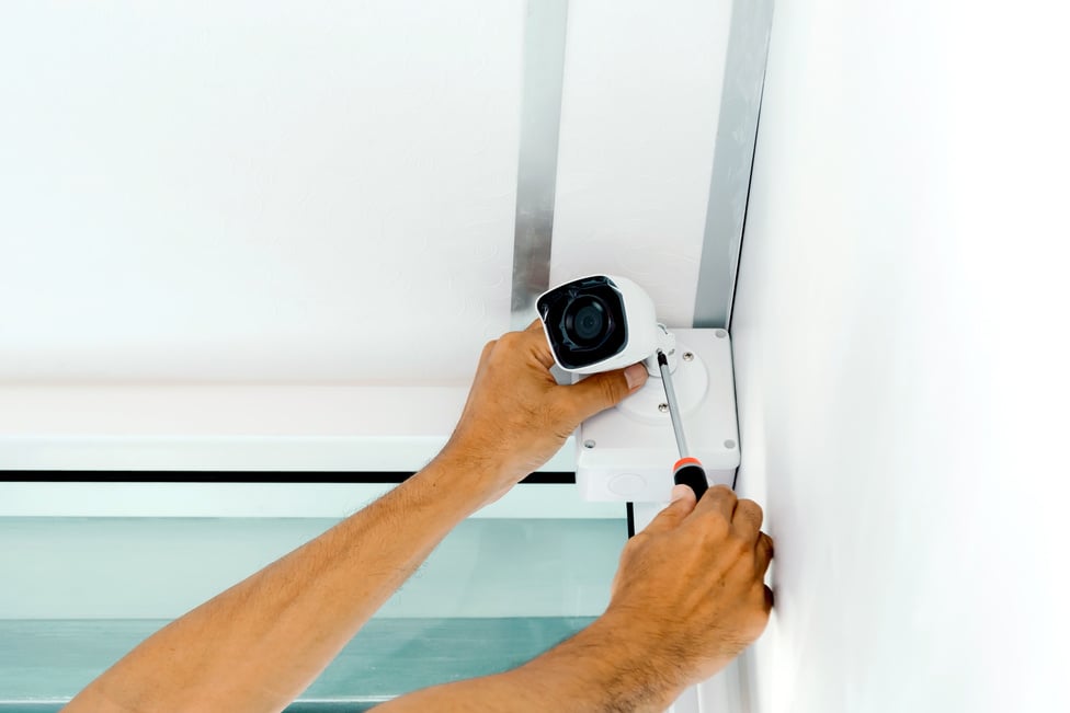 Technicians using a screwdriver to install  the CCTV cameras